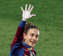 a woman wearing a nike jersey waves her hand