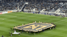 a group of people holding up a large los angeles shield on a soccer field