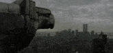 a statue of an eagle looks out over a city with the twin towers in the background