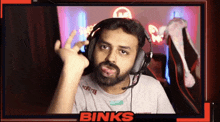 a man with a beard wearing headphones and a shirt that says binks