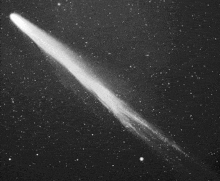 a black and white photo of a comet flying through the night sky