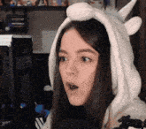 a woman wearing a unicorn costume is talking into a microphone