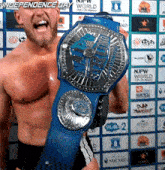 a shirtless wrestler is holding a blue wrestling championship belt in front of a wall with npw world logos on it