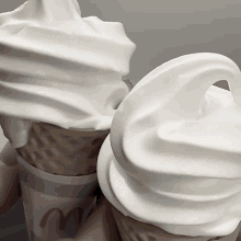 two ice cream cones with white frosting and a cup that says mcdonald 's