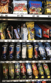 a vending machine contains a variety of snacks and drinks including red bull and m & m 's