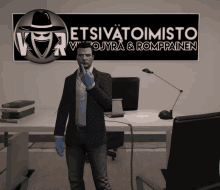 a man in a suit stands in front of a sign that says etsivatoimisto