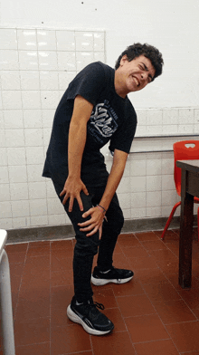 a young man wearing a shirt that says ' snoopy ' on it is standing on a tiled floor