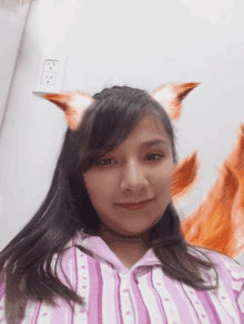 a girl with fox ears on her head is wearing a striped shirt