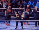 a man is holding a trophy in a boxing ring while wearing a shirt that says ' one ' on it