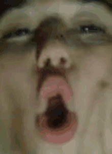 a close up of a person making a funny face with their mouth open .