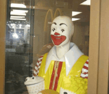 a statue of mcdonald 's ronald mcdonald holding a cup