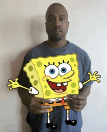 a man in a blue shirt is holding a cartoon of spongebob squarepants