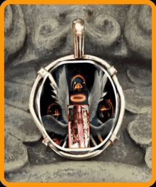 a pendant with a picture of an angel in it is sitting on a rock .