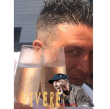 a man holds two glasses of champagne in front of a poster that says " vivere "