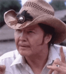 a man wearing a cowboy hat and a white shirt