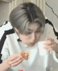 a man is eating a piece of food with a spoon .