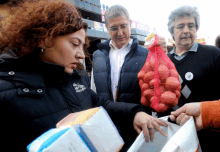 a woman holds a bag of potatoes while a man holds a bag of potatoes