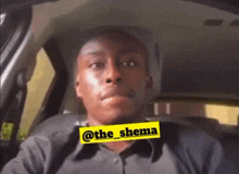 a man is sitting in a car with a yellow sticker that says @the_shema