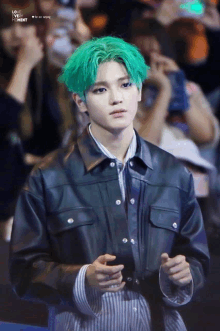 a young man with green hair and a black jacket