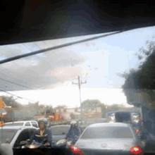 a man is riding a motorcycle in a traffic jam on a busy street .