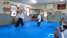 a group of men are practicing martial arts in a room with a banner that says ' martial arts association ' on it