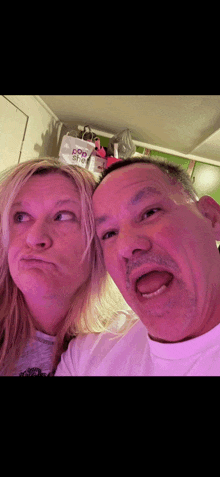 a man and a woman are making funny faces in front of a bag that says dog food