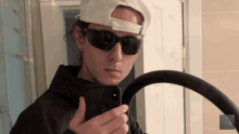 a man wearing sunglasses and a hat takes a picture of himself