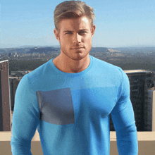 a man in a blue shirt is standing in front of a city skyline