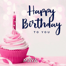 a pink cupcake with a lit candle and the name maya on it