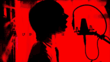 a silhouette of a person singing into a microphone with chinese writing in the background