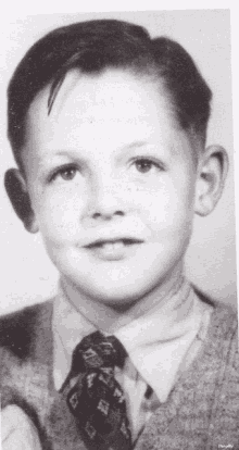 a black and white photo of a young boy with a tie