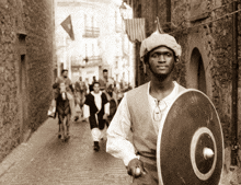 a man carrying a shield with a circle on it