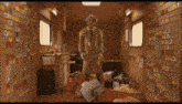 a man in a space suit is standing in a room with a lot of stickers on the walls