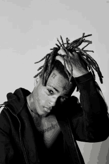 a black and white photo of a person with dreadlocks