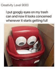 a red trash can with googly eyes on it is sitting on a wall .