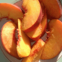 a plate of sliced peaches with a bite taken out of one of them