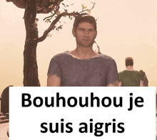 a man standing in front of a tree with a sign that says bouhouhou je suis aigris