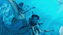 a woman in a blue avatar is swimming with a shark