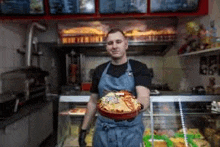 a man is holding a plate of food in a restaurant .