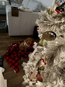 a small dog laying on a blanket under a christmas tree