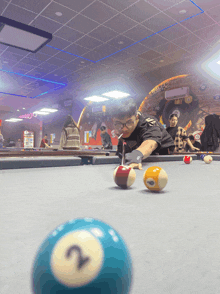 a man playing pool with the number 2 on the ball