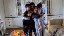 a family posing for a picture in a living room with a clock on the wall that shows the time as 6:45