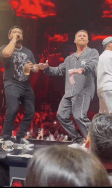 a man in a black shirt with the letter f on it is dancing on stage