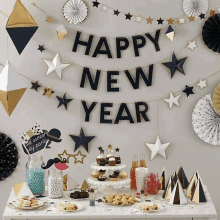 a table set up for a new year 's eve party with a happy new year banner