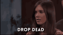 a close up of a woman 's face with the words `` drop dead '' written on the bottom .