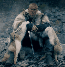 a man in a fur coat holds a sword in his hand