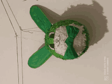 a green and white bunny piñata with a bow