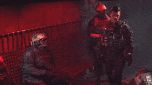 a group of soldiers are standing in a dark room with a red background