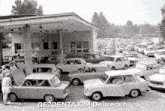 a black and white photo of cars parked in front of a building with 0670entaxim debrecen written on the bottom