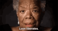 a close up of a woman 's face with the words `` love liberates '' .